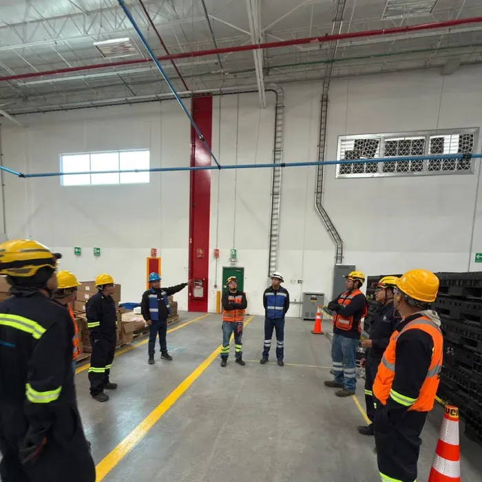 Cuadrilla de iT Power Systems en una charla de seguridad previa a la maniobra, dentro de una nave industrial